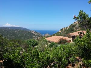 dom na wzgórzu z oceanem w tle w obiekcie Villino Mamy w mieście Costa Paradiso