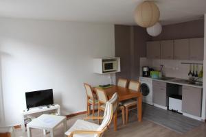a kitchen and dining room with a table and chairs at Le Châtaignier in Forbach
