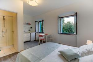 a bedroom with a bed and a kitchen with a table at BigBlue house in Veli Lošinj