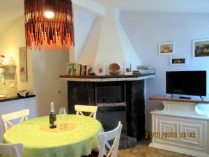 a dining room with a table and a fireplace at Villa D Apartments in Marino