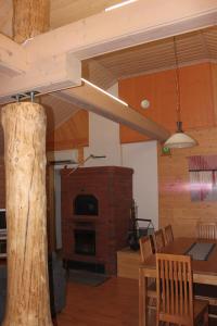 a dining room with a table and a wood stove at Kuusitorppa in Varpaisjärvi