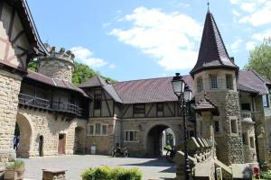 a large stone building with a tower and a turret at Le Châtaignier in Forbach