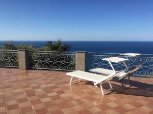 - 2 chaises et une table sur une terrasse donnant sur l'océan dans l'établissement B&B Le Palme, à Ameglia