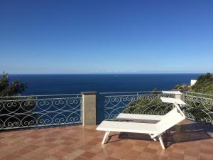 une chaise blanche assise sur un balcon donnant sur l'océan dans l'établissement B&B Le Palme, à Ameglia