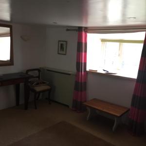 a room with a window and a table and a bench at Littlebridge Farmhouse in Bude