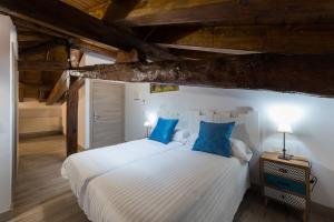 una camera da letto con un grande letto bianco con cuscini blu di Petit Goierri a Ormáiztegui