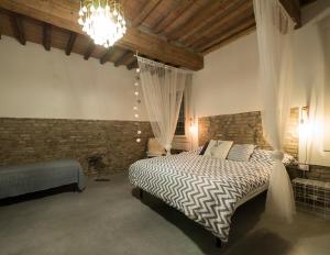 Schlafzimmer mit einem Bett und einem Kronleuchter in der Unterkunft Zucchero sui Baffi- Food Lovers B&B in Mantua