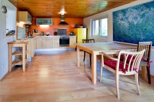 eine Küche und ein Esszimmer mit einem Holztisch und Stühlen in der Unterkunft Ferienhaus Bergblick in Schwarzenberg im Bregenzerwald