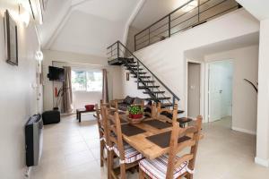 a living room with a wooden table and a spiral staircase at Soltigua Apart Hotel Mendoza in Mendoza