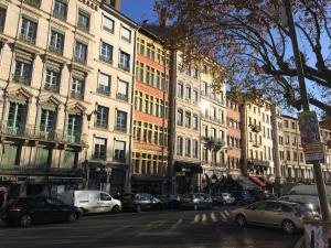 una calle de la ciudad con coches estacionados frente a los edificios en Studio Charme et Confort aux Cordeliers, en Lyon
