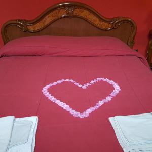 ブリンディジにあるbebvialataのベッドの上のピンクのビーズで作られたハート