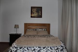 um quarto com uma cama e uma fotografia na parede em Quinta Cho do Nabal em Belmonte