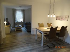 ein Esszimmer und ein Wohnzimmer mit Tisch und Stühlen in der Unterkunft Ferienwohnung Haus Nr. 11 in Warendorf
