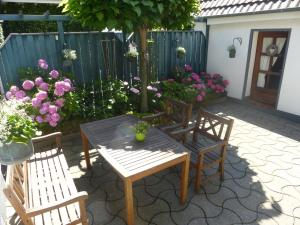 eine Terrasse mit Tisch und Stühlen und Blumen in der Unterkunft Ferienwohnung Haus Nr. 11 in Warendorf