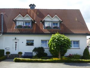 ein weißes Haus mit einem roten Dach in der Unterkunft Ferienwohnung Haus Nr. 11 in Warendorf