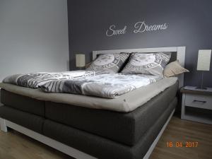 ein Bett in einem Schlafzimmer mit dem Wort und Träumen an der Wand in der Unterkunft Ferienwohnung Haus Nr. 11 in Warendorf