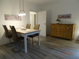 einen Esstisch mit Stühlen und eine Kommode in der Unterkunft Ferienwohnung Haus Nr. 11 in Warendorf + 2 Fotos