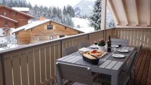 a picnic table on a balcony with a table of food at Chalet Brunner Penthouse in Wengen