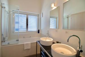 a bathroom with a sink and a tub and a mirror at Chalet Brunner Penthouse in Wengen +18 photos