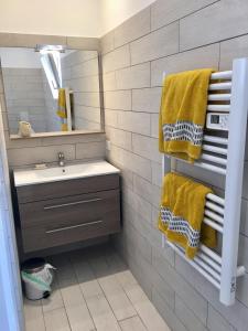 a bathroom with a sink and yellow towels at I Tre Sirenelli in Propriano