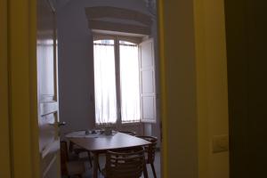 uma sala de jantar com uma mesa e uma janela em Vico sferracavalli em Lecce
