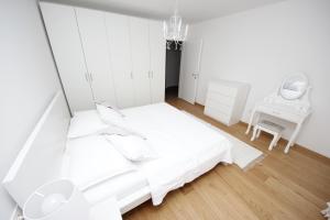 a white bedroom with a bed and a mirror at Villa More in Makarska