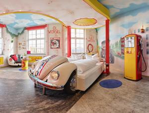 ein Zimmer mit einem Bett in einem Autozimmer in der Unterkunft V8 HOTEL Classic Motorworld Region Stuttgart in Böblingen