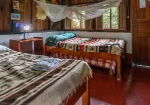 a bedroom with two beds and a window at Finca Ixobel in Ixobel