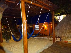 Hotel Amar Inn في بويرتو موريلوس: أرجوحة في منزل على الشاطئ في الليل