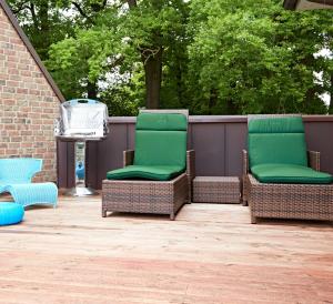 2 Stühle auf einer Terrasse mit Grill in der Unterkunft Eichenlodge in Apensen