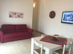 a living room with a red couch and a table at Casa Bice - IUN P4163 in Alghero