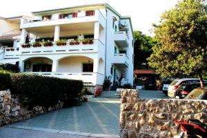 a white building with plants on the side of it at Apartments Frgacic in Baška