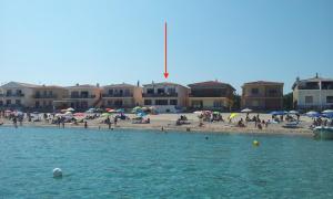 a group of people on a beach with buildings at On The Beach La Rena Beddha in Aglientu