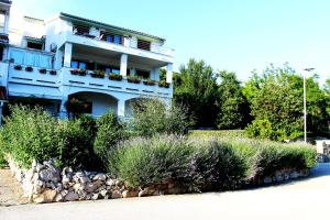 a building with a bunch of bushes in front of it at Apartments Frgacic I in Baška