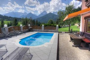 a swimming pool in a patio with mountains in the background at Haus Steinwaendt in Hinterstoder
