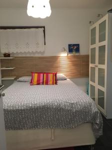 アルブフェイラにあるEstúdio tranquilo praia da Falésiaのベッドルーム1室(大型ベッド1台、カラフルな枕付)