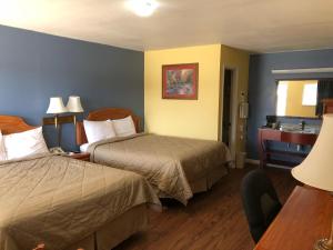 a hotel room with two beds and a desk at Gold Key Inn in Brady