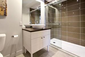 a bathroom with a sink and a shower at INITIAL - OLYMPIQUE - Mont-Sainte-Anne in Beaupré