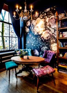 アムステルダムにあるRosalia's Menagerie Cocktail bar & InnUpstairsの花の壁の客室内のテーブルと椅子