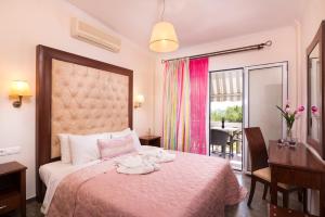 una camera d'albergo con letto, scrivania e finestra di San Antonio Beach Apartments a Potos