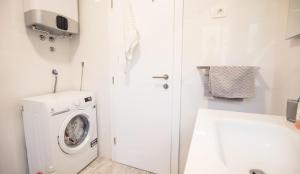 a white laundry room with a washing machine in it at Apartment Zamarin 1 in Drvenik