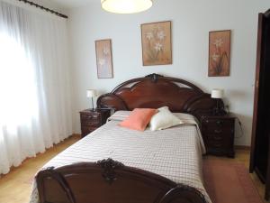 a bedroom with a large wooden bed with two pillows at Berdullas in Vilagarcia de Arousa