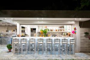 a restaurant with a bar with silver metal chairs at San Antonio Beach Apartments in Potos