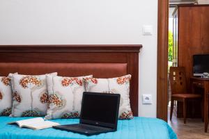 a laptop computer sitting on a bed with a book at San Antonio Beach Apartments in Potos