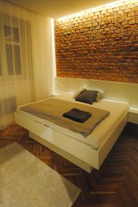 Cama en habitación con pared de ladrillo en Apartments Centre in Style en Olomouc