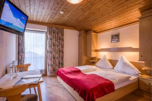 Habitación de hotel con cama y TV de pantalla plana. en Walchenhof, en Mayrhofen