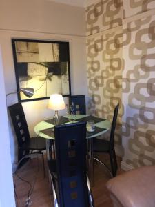 um quarto com uma mesa, cadeiras e um candeeiro em Scotstoun 1 Bed Flat em Glasgow