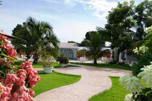 Una pasarela a través de un jardín con palmeras y un edificio en Delcas Hotel, en Cuiabá
