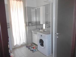 uma casa de banho com uma máquina de lavar roupa e um lavatório em Residence Mirage Milazzo em Milazzo