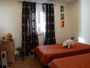 a stuffed dog sitting on a bed in a bedroom at A Primeira Casinha do Mé-Mé in Manteigas